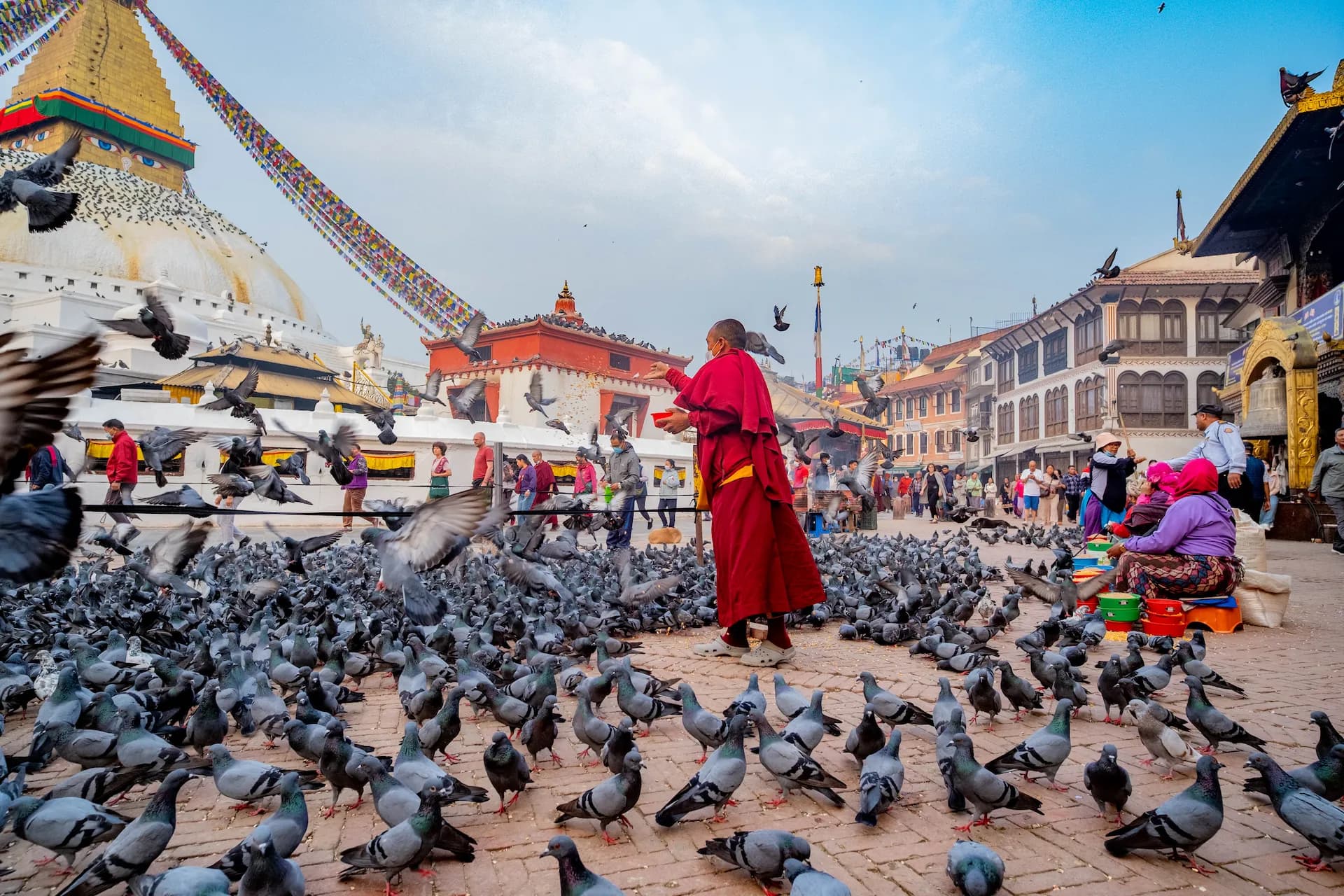 Monk feeding doves at Boudha, Kathmandu